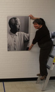 Pam Meister, curator and interim director of the Mountain Heritage Center, stands next to a photo of Nelson Mandela in the Apartheid exhibit. 