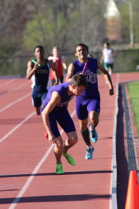 Dylan Andrade handing off the baton to Justin Kenard in the 400 meter relay. Photo by Calvin Inman