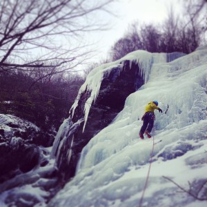 Haas climbing up the face of an ice wall. Photo by 