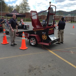 Officer stands by as the next volunteer lines up to get on the Convincer. Photo by David Johnson. 