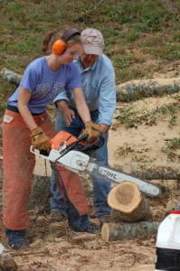 Sophomore Ali Coscore learns how to operate the chainsaw